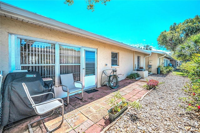 rear view of property with a patio area and stucco siding