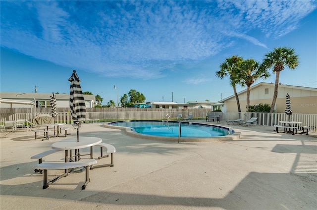 pool with a fenced backyard and a patio