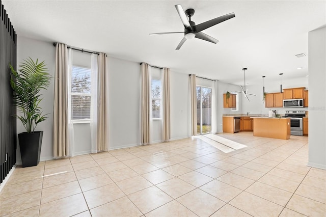 unfurnished living room with light tile patterned floors, visible vents, baseboards, and ceiling fan