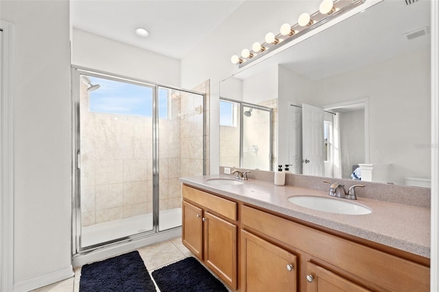 full bath featuring tile patterned flooring, double vanity, a stall shower, and a sink