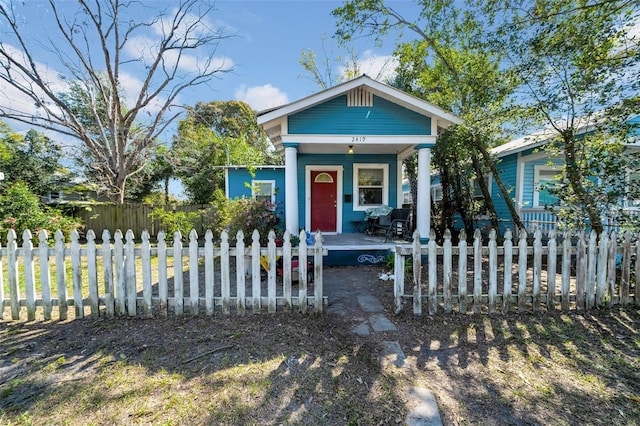 view of front of home with a fenced front yard and covered porch