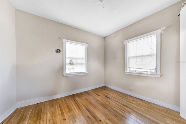 spare room featuring baseboards and hardwood / wood-style floors