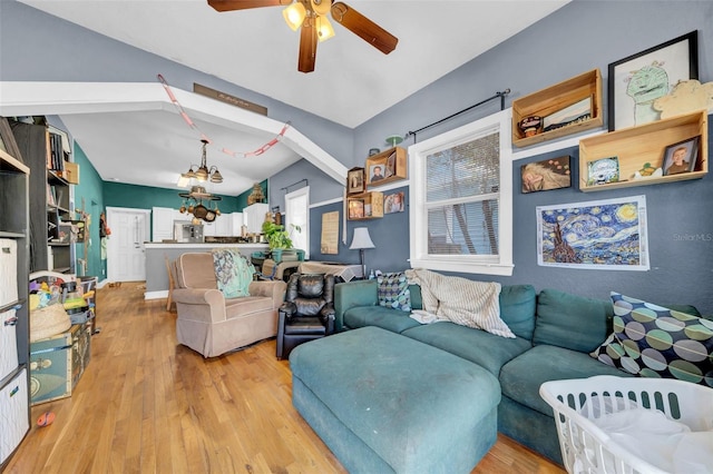 living area with vaulted ceiling, wood finished floors, and a ceiling fan