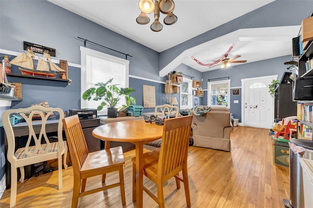 dining space featuring ceiling fan with notable chandelier and hardwood / wood-style flooring