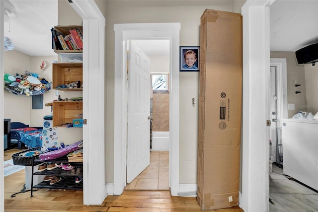 hallway featuring washer / clothes dryer and light wood finished floors