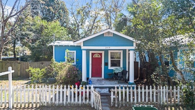 view of front of property featuring covered porch and a fenced front yard