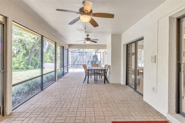 sunroom / solarium featuring outdoor dining space and a ceiling fan