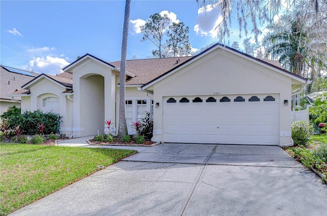 ranch-style home featuring a front yard, driveway, an attached garage, and stucco siding