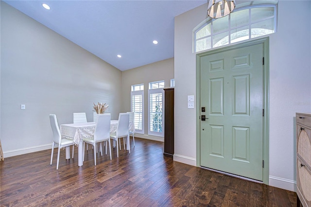 foyer with lofted ceiling, recessed lighting, dark wood finished floors, and baseboards