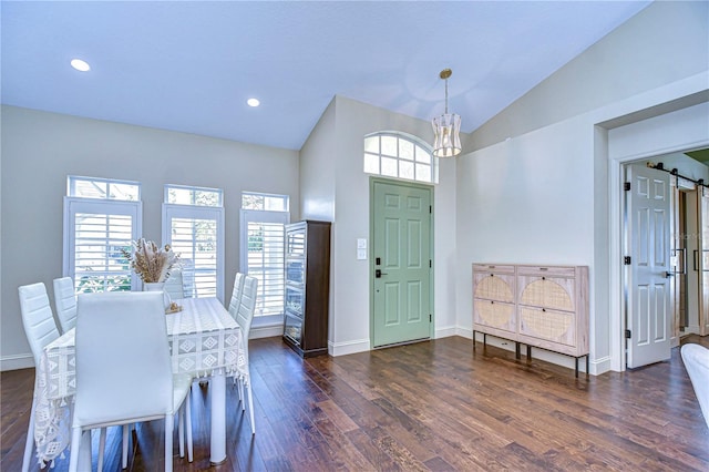 foyer entrance featuring vaulted ceiling, dark wood finished floors, baseboards, and a barn door