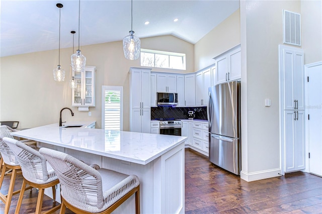 kitchen with a breakfast bar, visible vents, appliances with stainless steel finishes, a sink, and a peninsula