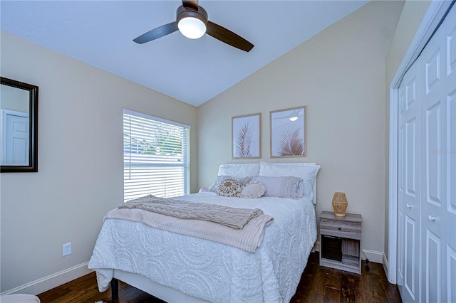 bedroom featuring vaulted ceiling, a closet, wood finished floors, and baseboards