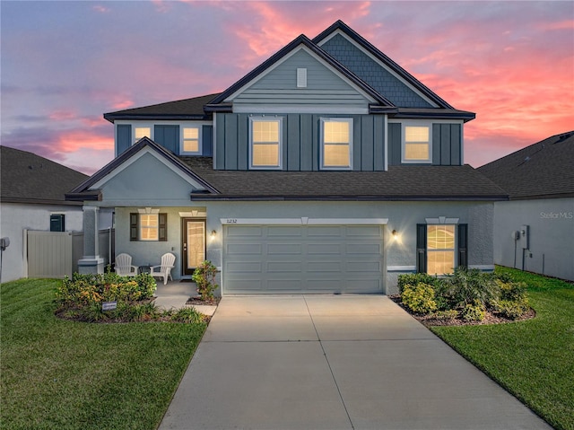 traditional-style house with a garage, driveway, stucco siding, a front lawn, and board and batten siding