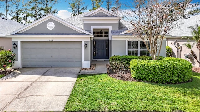 single story home with a garage, a shingled roof, concrete driveway, stucco siding, and a front lawn