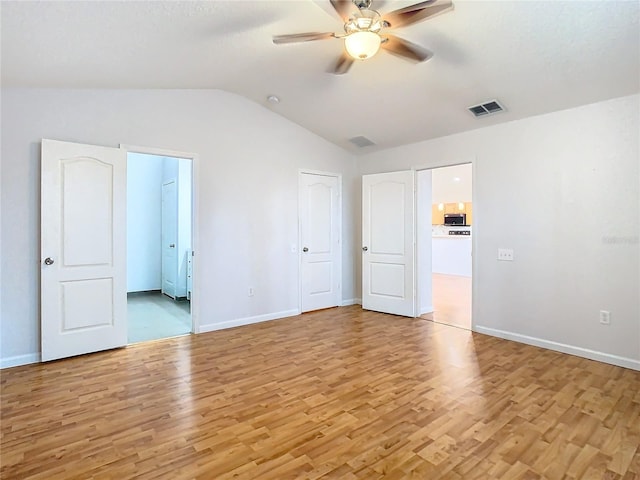 5351 Lookout Pass, Wesley Chapel, FL 33544 - unfurnished bedroom featuring baseboards, visible vents, light wood-style floors, and lofted ceiling