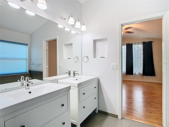 5351 Lookout Pass, Wesley Chapel, FL 33544 - bathroom with a sink, two vanities, vaulted ceiling, baseboards, and wood finished floors