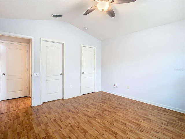 5351 Lookout Pass, Wesley Chapel, FL 33544 - unfurnished bedroom featuring visible vents, light wood-style floors, baseboards, vaulted ceiling, and a ceiling fan