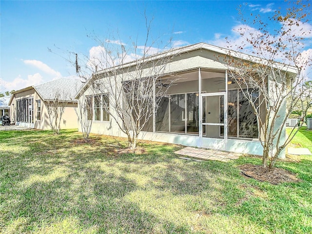 5351 Lookout Pass, Wesley Chapel, FL 33544 - rear view of house featuring stucco siding, a ceiling fan, a yard, and a sunroom