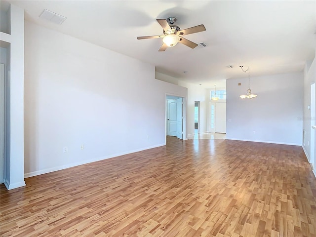 5351 Lookout Pass, Wesley Chapel, FL 33544 - unfurnished living room featuring ceiling fan with notable chandelier, visible vents, baseboards, and light wood-type flooring