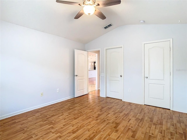 5351 Lookout Pass, Wesley Chapel, FL 33544 - unfurnished bedroom featuring light wood-type flooring, a ceiling fan, visible vents, vaulted ceiling, and baseboards