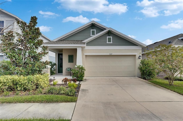 view of front facade featuring a garage, concrete driveway, a shingled roof, and stucco siding