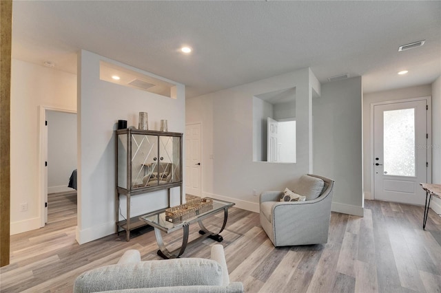 living area featuring visible vents, recessed lighting, light wood-style flooring, and baseboards