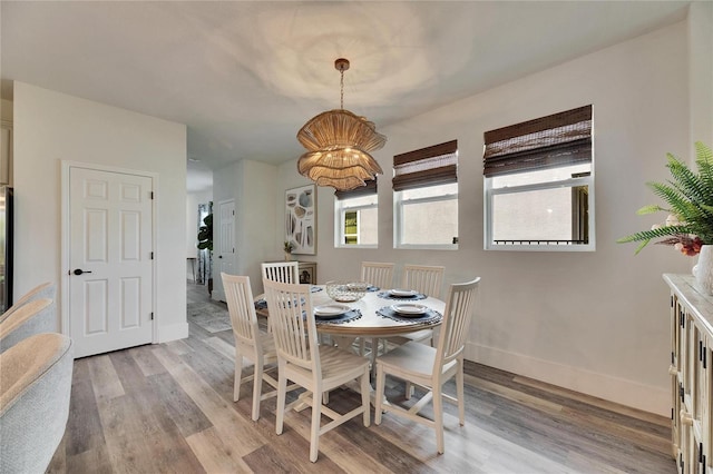 dining space featuring light wood-style flooring and baseboards