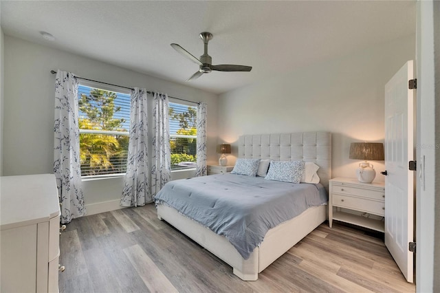 bedroom with light wood-style floors, baseboards, and a ceiling fan