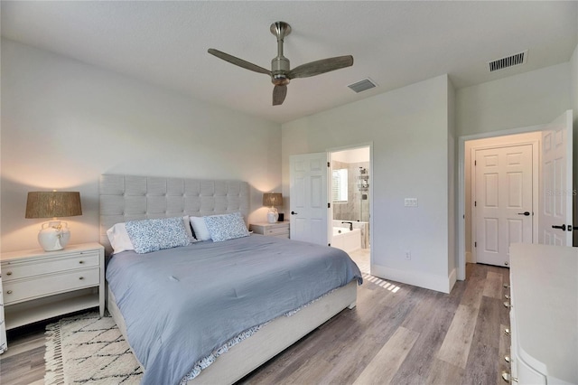 bedroom with light wood-style flooring, ensuite bath, visible vents, and baseboards