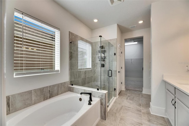 bathroom with a garden tub, vanity, baseboards, a spacious closet, and a shower stall