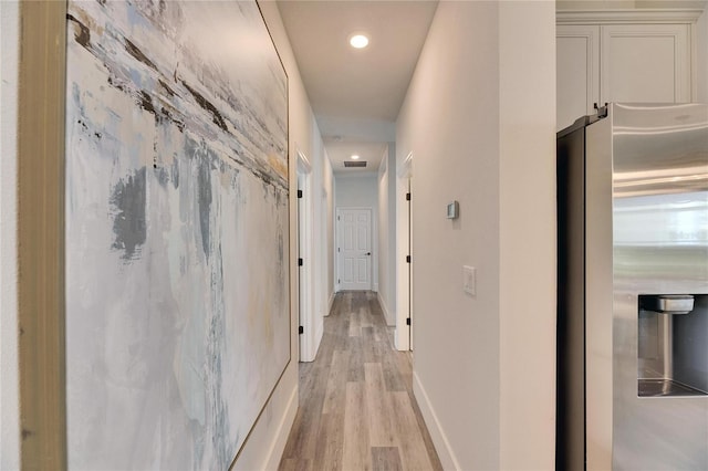 corridor with light wood finished floors, visible vents, baseboards, and recessed lighting