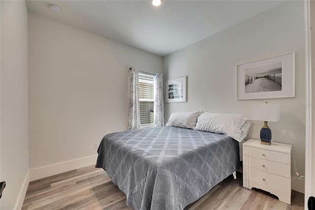 bedroom featuring light wood-style floors and baseboards