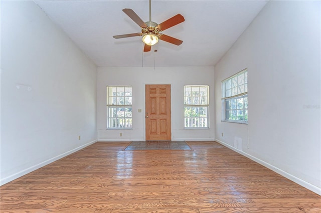 interior space featuring lofted ceiling, baseboards, and wood finished floors