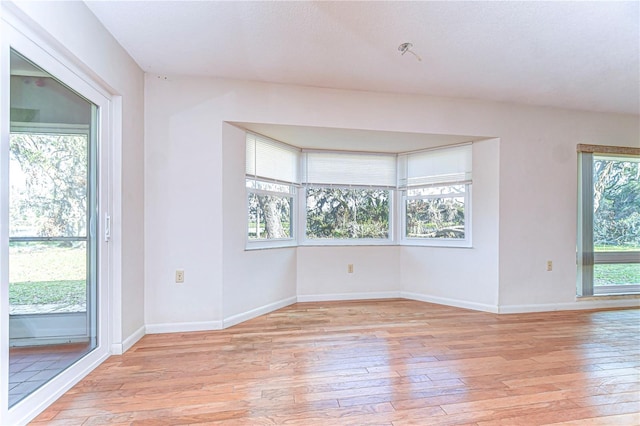 spare room featuring light wood-type flooring and baseboards