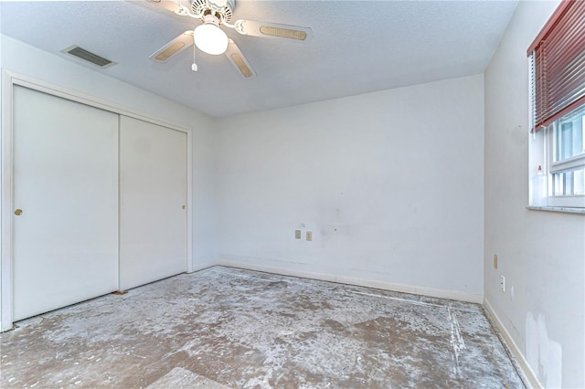 unfurnished bedroom featuring a closet, visible vents, a ceiling fan, a textured ceiling, and baseboards