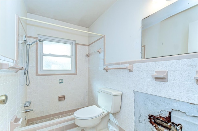 full bathroom with shower / washtub combination, wainscoting, tile walls, and toilet