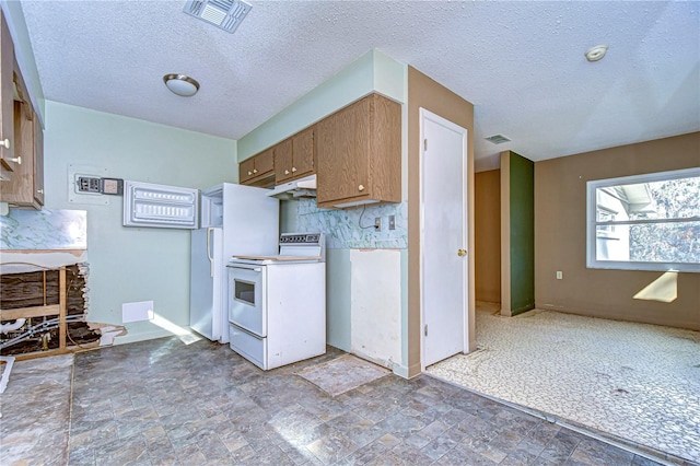 kitchen featuring white range with electric stovetop, brown cabinets, visible vents, stone finish flooring, and under cabinet range hood