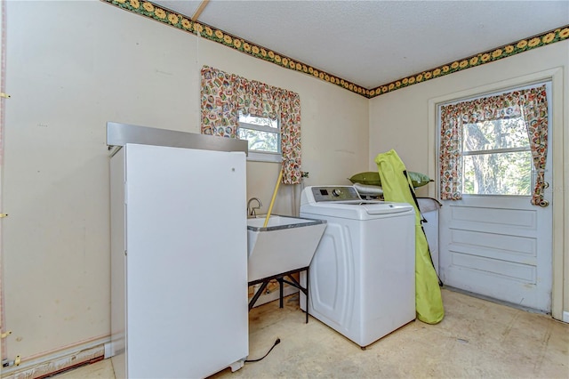 laundry room with washer / clothes dryer, a sink, a textured ceiling, and laundry area