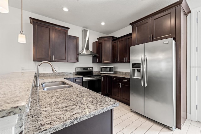 kitchen featuring dark brown cabinetry, recessed lighting, a sink, appliances with stainless steel finishes, and wall chimney range hood