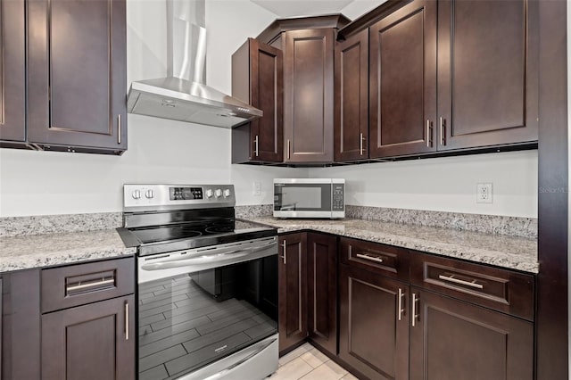 kitchen featuring appliances with stainless steel finishes, light stone counters, wall chimney range hood, and dark brown cabinets