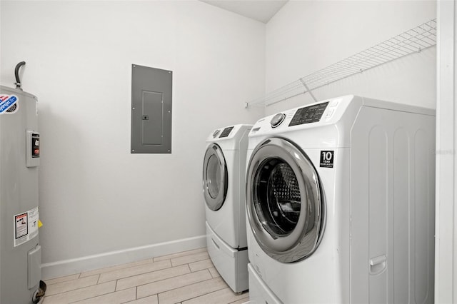 washroom featuring electric water heater, light wood-style flooring, laundry area, separate washer and dryer, and electric panel