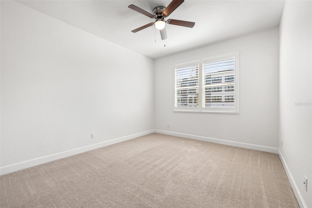 unfurnished room featuring light carpet, a ceiling fan, and baseboards