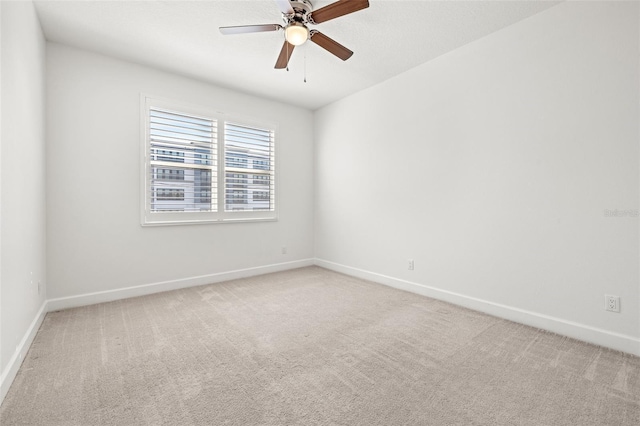 empty room featuring light carpet, ceiling fan, and baseboards