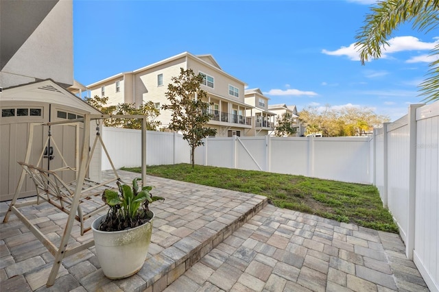 view of patio featuring a fenced backyard, an outdoor structure, and a shed