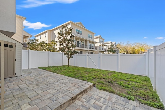 view of yard featuring a residential view, a patio area, and a fenced backyard