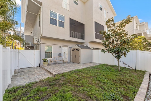 back of house featuring a gate, a fenced backyard, a patio, and stucco siding