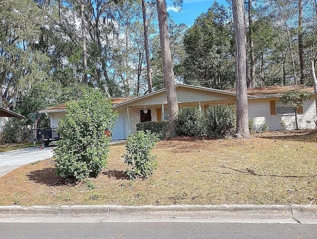 single story home featuring concrete driveway, brick siding, and an attached garage