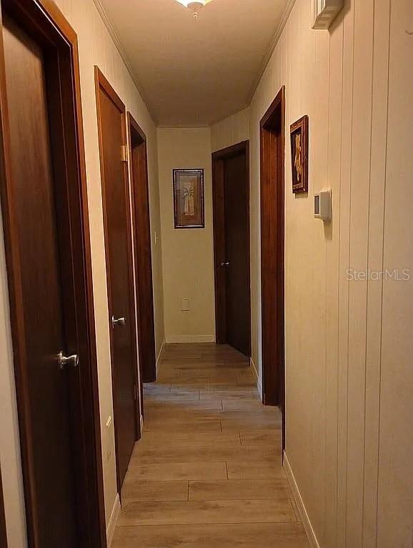 corridor featuring baseboards and light wood-style floors