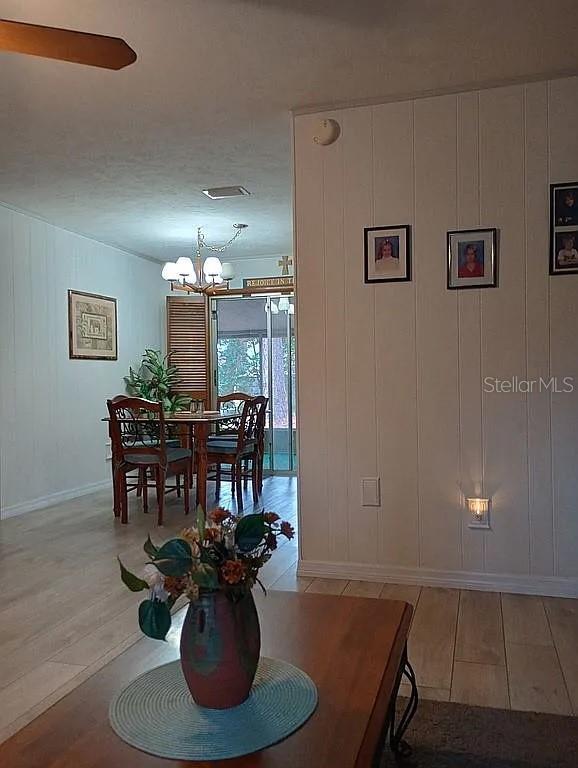 dining space with visible vents, light wood-style flooring, and an inviting chandelier