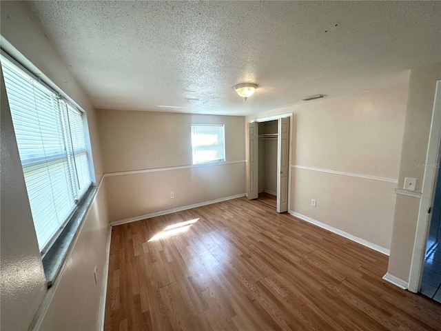 unfurnished bedroom featuring a closet, baseboards, and wood finished floors